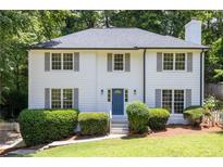 Charming two-story home with a well-manicured lawn, featuring a classic white facade and gray shutters at 1172 Colony Dr, Marietta, GA 30068