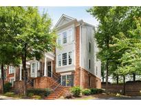 Attractive three-story townhome featuring brick facade, multiple windows, and landscaped entry at 2305 Limehurst Ne Dr # 21, Atlanta, GA 30319
