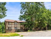 Inviting two-story home showcasing its unique Tudor style and mature trees in a tranquil setting at 1308 Camelot Dr, Atlanta, GA 30349