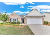 Charming single-story home with a well-manicured lawn, brick facade, and two-car garage at 936 Village View Cir, Loganville, GA 30052
