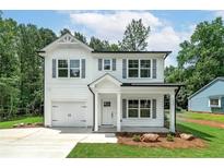 Charming two-story home with white siding, gray shutters, and well-manicured front yard at 1534 River Rock Trce, Woodstock, GA 30188