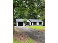 Charming single-story home with a black-trimmed garage and black-framed windows, surrounded by lush greenery at 168 Park Ln, Dallas, GA 30157