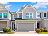 Charming townhome featuring a large garage, neutral siding, and manicured landscaping at 804 Whittington Sw Pkwy, Marietta, GA 30060