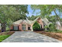 Charming brick home featuring mature trees, manicured landscaping, and a long driveway at 1635 Lake Heights Cir, Dacula, GA 30019