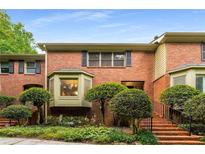 Charming brick townhouse with manicured landscaping and stairs leading to the front door at 1378 Sheffield Glen Ne Way, Atlanta, GA 30329