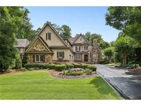 Charming two-story home featuring a stone facade, manicured lawn, and private driveway at 145 Ardsley Ln, Alpharetta, GA 30005