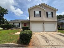 Two story home with two car garage, red door, and manicured lawn at 2183 Ramblewood Cir, Decatur, GA 30035