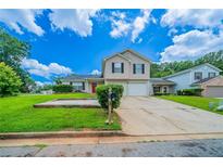 Inviting two-story home featuring a well-manicured lawn and a driveway leading to an attached garage at 2183 Ramblewood Cir, Decatur, GA 30035