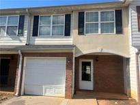 Charming two-story townhouse with a one-car garage and a brick-accented front porch entry at 730 Georgetown Ln, Jonesboro, GA 30236