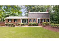 Charming single-story brick home featuring a well-manicured lawn and lush landscaping at 2179 Mountclaire Ct, Stone Mountain, GA 30087