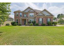 Charming brick two-story home with a well-manicured lawn and a welcoming front entrance at 4315 Balsam Bark Dr, Cumming, GA 30028