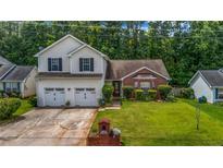 Charming two-story home with a well-manicured lawn, two-car garage and manicured yard with mature trees at 5485 Shirewick Ln, Lithonia, GA 30058