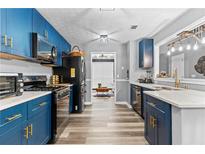 Modern kitchen featuring blue cabinetry, stainless steel appliances, and an open layout at 3229 Dunlin Lake Rd, Lawrenceville, GA 30044