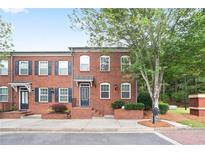 Charming brick townhome with black shutters, landscaped front, and a beautifully manicured front lawn at 4130 Stonecypher Rd, Suwanee, GA 30024