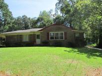 Charming brick home featuring a spacious front yard and mature trees, offering both curb appeal and privacy at 1410 Willis Mill Sw Rd, Atlanta, GA 30311
