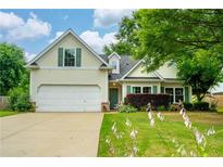 Charming home featuring a manicured lawn, inviting curb appeal, and attached garage at 5279 Leecroft Dr, Buford, GA 30518
