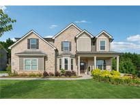 Charming two-story brick home with a well-manicured lawn and colorful landscaping at 4090 Sierra Knolls Ct, Cumming, GA 30040