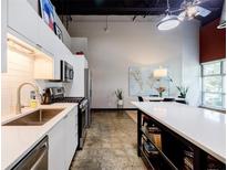 Modern kitchen featuring stainless steel appliances and white cabinetry in an open-concept living space at 5200 Peachtree Rd # 1104, Atlanta, GA 30341