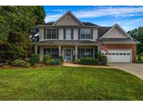 Charming two-story home with a well-manicured lawn, inviting front porch, and attached two-car garage at 15 Saddlebrook Ct, Covington, GA 30016