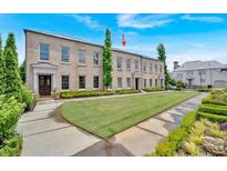 Beautiful brick townhouse featuring manicured front lawn and lush landscaping at 102 Grand Cres, Alpharetta, GA 30009