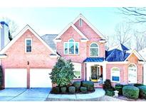 Charming brick home featuring a manicured front yard and a two-car garage at 1301 Dayspring Trce, Lawrenceville, GA 30045