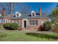 Charming brick home featuring dormer windows, a gray roof, and a well-maintained front yard at 469 Mellview Sw Ave, Atlanta, GA 30310