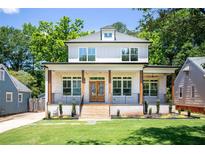 Charming two-story home featuring a brick porch, wood pillars, and well-manicured lawn at 2808 Hosea L Williams Dr, Atlanta, GA 30317