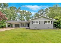 Charming single-story home with grey brick and a well-manicured lawn at 4477 Timber Ridge Dr, Douglasville, GA 30135