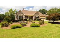 Charming stone front exterior with a well-manicured lawn and beautiful landscaping at 3785 Glen Ian Dr, Loganville, GA 30052
