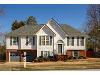 Charming two-story home boasts a brick-accented facade and a well-manicured lawn with mature landscaping at 1305 Bramlett Forest Trail Southeast Trl, Lawrenceville, GA 30045
