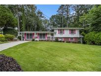 Charming split-level home with a well-manicured lawn and colorful shutters at 2983 Peek Nw Rd, Atlanta, GA 30318
