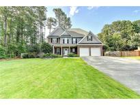 Traditional two-story home featuring a well-manicured lawn and a two-car garage at 4845 Dartford Dr, Powder Springs, GA 30127