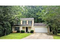Charming two-story home with a well-manicured lawn, mature trees, and a two-car garage at 4927 Millstone Walk, Stone Mountain, GA 30088