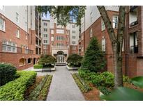 Beautiful exterior of brick apartment building with manicured landscaping and courtyard entryway at 50 Biscayne Nw Dr # 2113, Atlanta, GA 30309