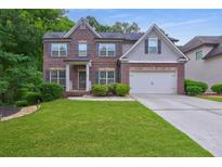 Charming two-story brick home with well-manicured lawn and a two car garage at 1239 Side Step Trace, Lawrenceville, GA 30045