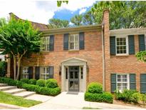 Charming brick townhouse featuring black shutters, manicured landscaping, and a welcoming entrance at 40 Olde Ivy Ne Sq, Atlanta, GA 30342