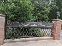 Lullwater Parc community entrance sign nestled amongst lush, mature greenery and a brick perimeter wall at 1634 Ponce De Leon Ne Ave # 512, Atlanta, GA 30307