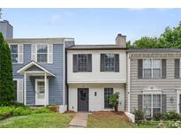Charming townhome with a well-maintained front yard, neutral exterior, and black shutters on a sunny day at 3072 Revere Ct, Atlanta, GA 30340
