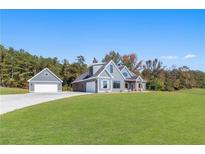 Charming home with lush lawn, detached garage, and modern gray siding against a vibrant blue sky at 101 Red Oak Ln, Carrollton, GA 30116