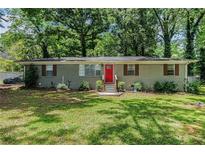 Charming brick home with a well-maintained front yard and a vibrant red front door at 200 Robin Hood Ln, Hampton, GA 30228