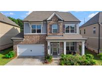Charming two-story home with a brick facade and inviting front porch at 3860 Oxford Park Ln, Cumming, GA 30040