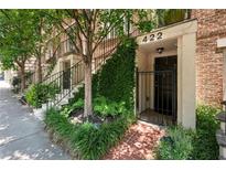 Charming townhome entrance featuring brick pathway, lush greenery, and a secure gated doorway at 422 Bill Kennedy Se Way, Atlanta, GA 30316