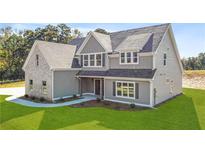 Charming two-story home with light gray siding, brick accent, and a beautifully landscaped front yard at 102 Red Oak Ln, Carrollton, GA 30116