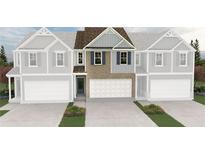 Two-story townhome showing brick and siding, two car garage and landscaping at 438 Lanier Cir, Woodstock, GA 30189