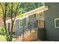 Elegant entrance featuring a wood door, dark gray brick, and black railings at 2524 Glenrock Dr, Decatur, GA 30032