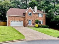 Charming brick two-story home with an attached two-car garage and well-manicured lawn at 4638 Villa Chase Ne Dr, Marietta, GA 30068