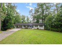 Charming single-story home with a long driveway and expansive green lawn at 5414 Iris Sw Dr, Mableton, GA 30126