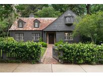 Charming home with brick walkway, gray wood fence and a neatly manicured green shrub border at 1860 Anjaco Nw Rd, Atlanta, GA 30309