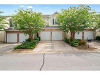 Inviting townhome featuring well-manicured landscaping, a private garage, and charming curb appeal at 125 Flatwood Trail, Marietta, GA 30066