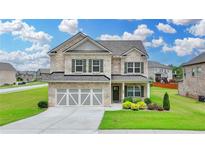 Stunning two-story brick home with a two-car garage, well-maintained lawn, and mature landscaping at 2090 Harvester Ln, Buford, GA 30518